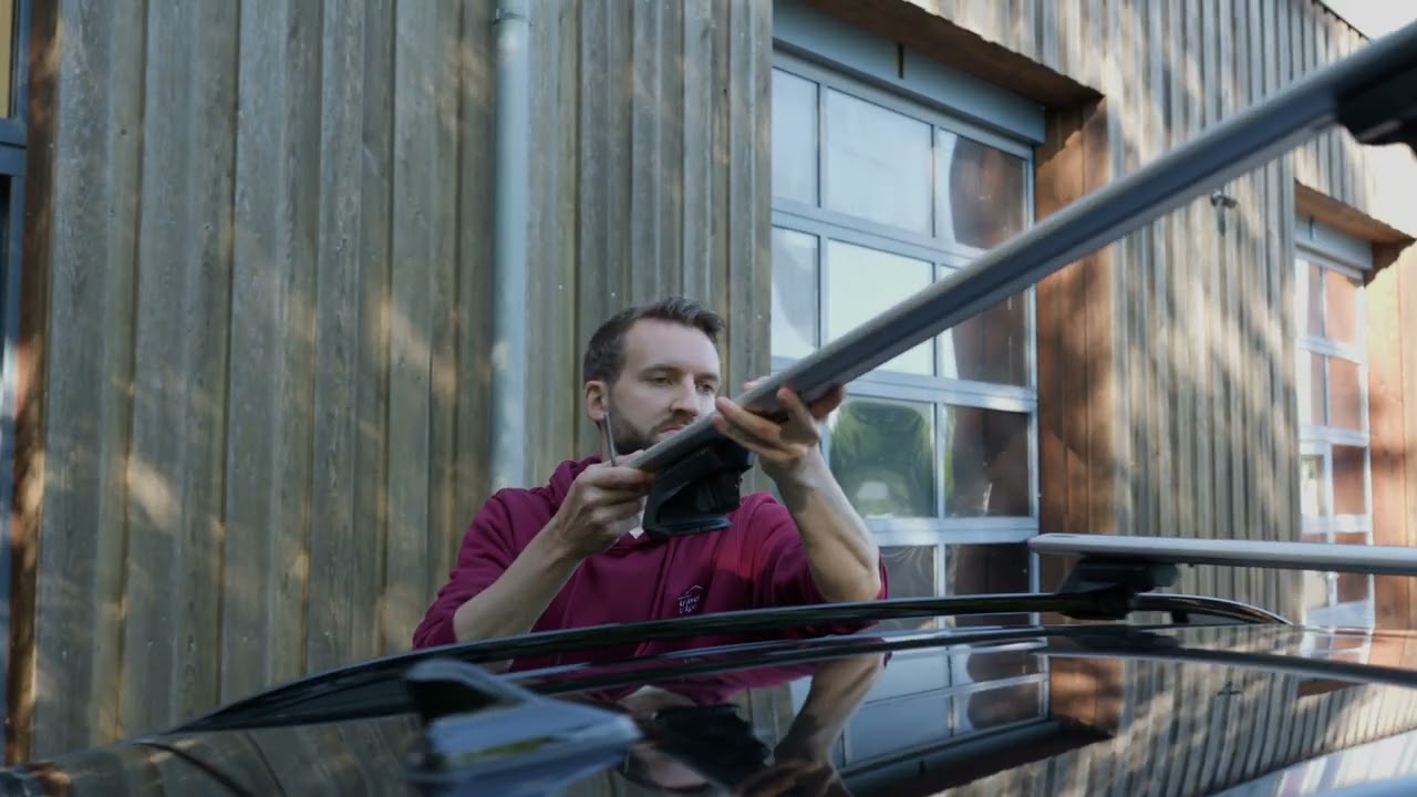 Montage von Thule Dachträgern auf einer offenen Dachreling