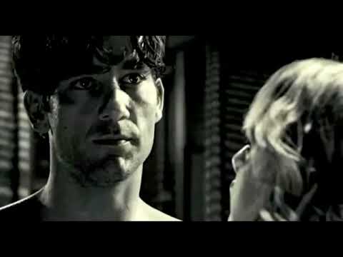 Sin City 2005 trailer frame: rain-slick noir streets and stark black-and-white with blood accents