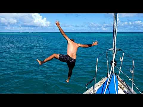 Enjoying the freedom of the sailing life with a bow jump in paradise