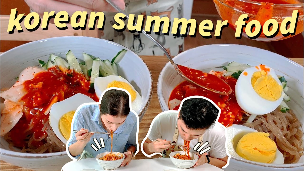 A bowl of Korean bibim naengmyeon cold spicy noodles topped with cucumber egg and red chili sauce arranged for a summer meal