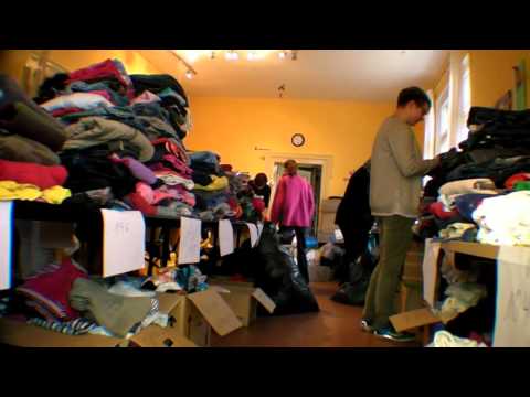 Ehrenamtliche packen  Pakete mit  Kinderkleidung