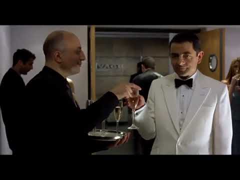 Johnny English 2003 official trailer frame: a tuxedoed Rowan Atkinson strides through MI7 corridors