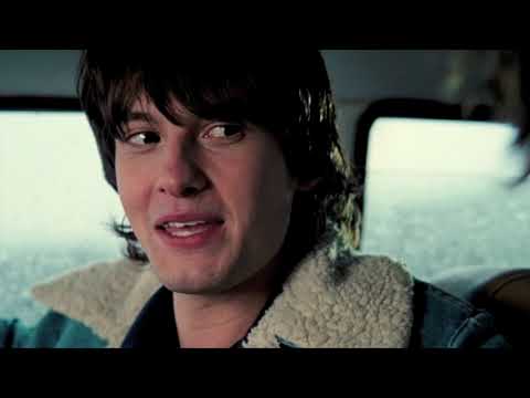 Trailer shot: the brothers on a bus at dusk, headphones sharing a demo