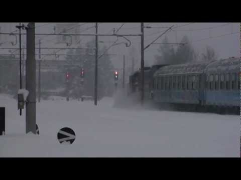 Diesel loco plowing through snow with a passenger train