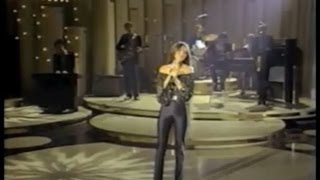 Crystal Gayle singing "Don't It Make My Brown Eyes Blue" in black spandex disco pants