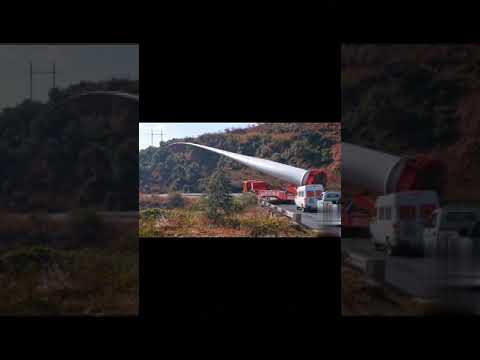 The wind turbine blade is transported by the adapter wind blade trailer to the top of the mountain.