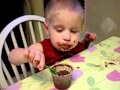 A Baby Eating His First Chocolate Pudding