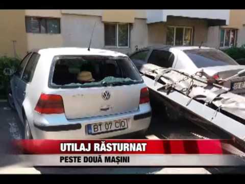 Utilaj răsturnat peste două maşini