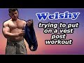 Muscle hunk trying to fit into vest post workout