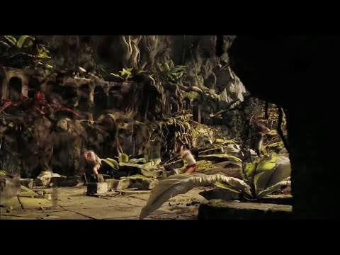 Trailer frame: crystal cavern glow and trio examining artifacts in Land of the Lost