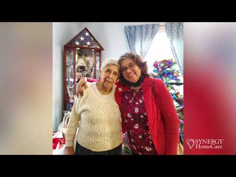Senior woman in wheelchair enjoying time in the park with caregiver