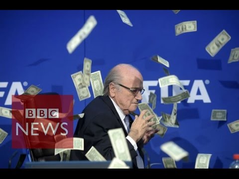 Moment Sepp Blatter was showered with fake dollar bills - BBC News