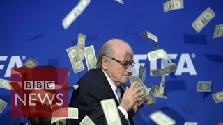 Moment Sepp Blatter was showered with fake dollar bills - BBC News