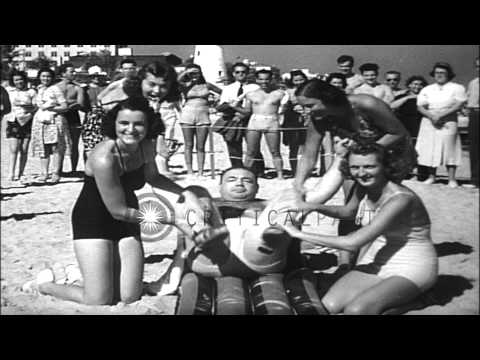 Girls helps Tony Galento to exercise while he drinks beer at  Miami Beach in Flor...HD Stock Footage