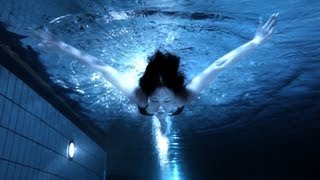 Beautiful midnight swimmer underwater in pool at n