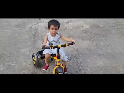 Insiya sitting on her tricycle