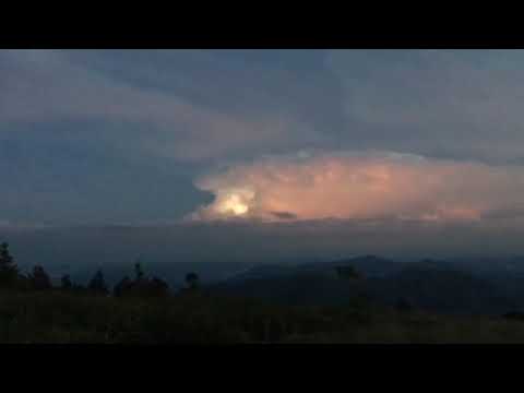 Thunderstorm and full moon over adjacent mountain.