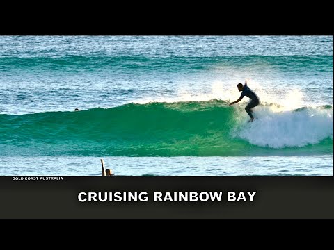 Surfing. Cruising Rainbow Bay on a Longboard.