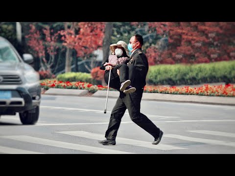 看到拄著拐杖的她，有人主動將她抱起！