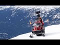 An explorer driving a camera-mounted snowmobile on icy slopes
