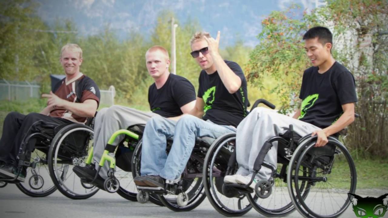 Four young guys in wheelchairs outside