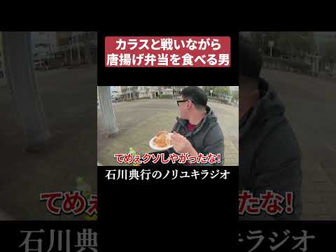 カラスと戦いながら唐揚げ弁当を食べる男