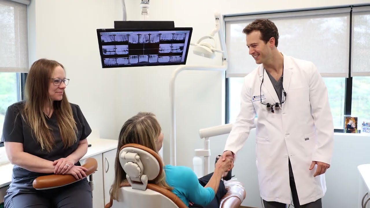 Doctor Tim smiling while shaking hands with dental patient