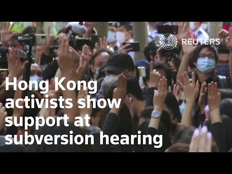 香港維權人士高呼抗議口號，人群聚集參加顛覆聽證會。 (Hong Kong activists chant protest slogans as crowds gather for subversion hearing)