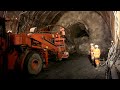 The largest tunnel in the world: miners facing the mountains