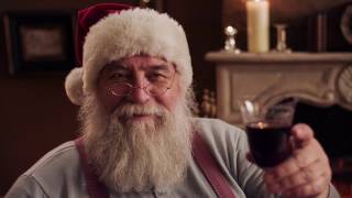 Video-Thumbnail von Videogrußbotschaft: Weihnachtsmann lächelt in Kamera und hält ein Rotweinglas zuprostend ins Bild