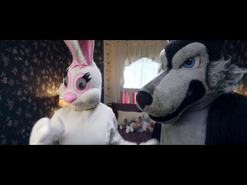 Trailer frame — Maynard and friends walk through snow-lit streets as a classic carol fades in