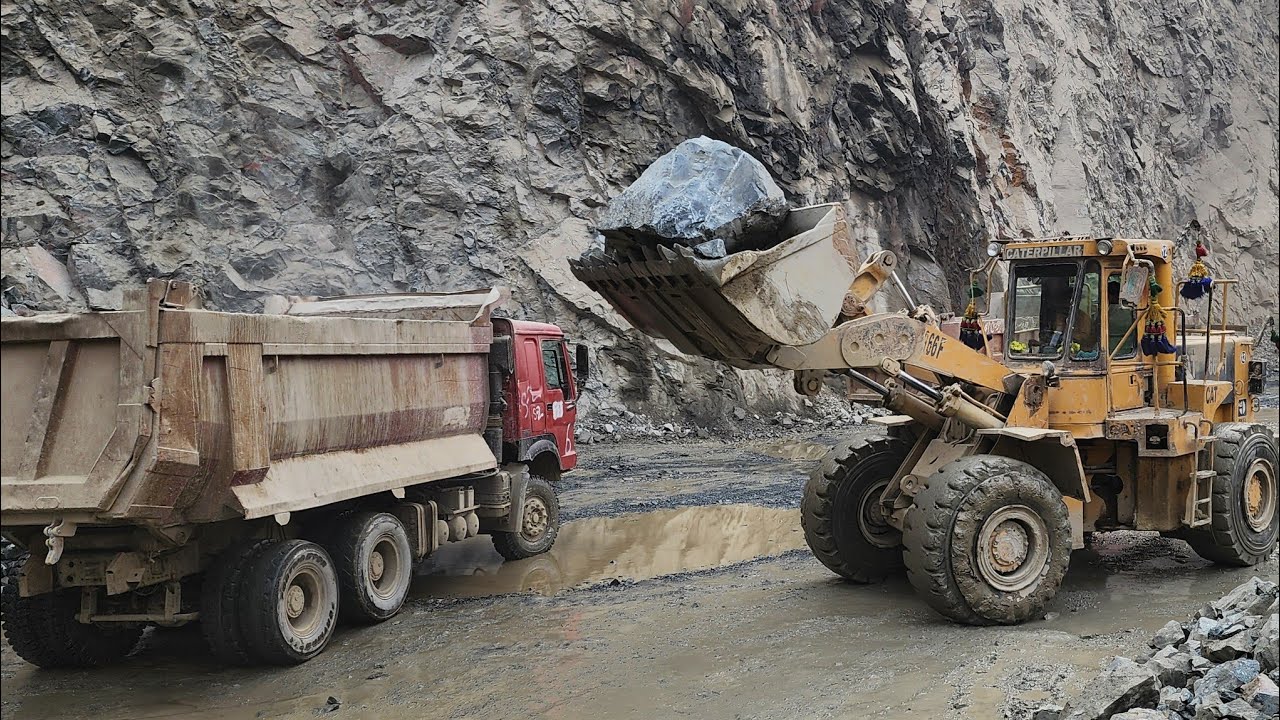 Caterpillar 966F at Heavy Work: Loading Massive Rocks into Dump Trucks and Trolleys