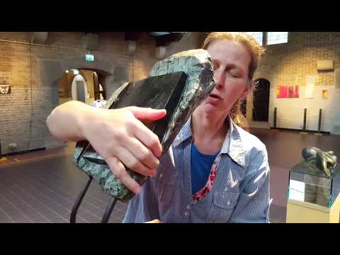 Bezoeker bekijkt sculptuur Akasha met haar handen en haar ogen dicht - Jofke