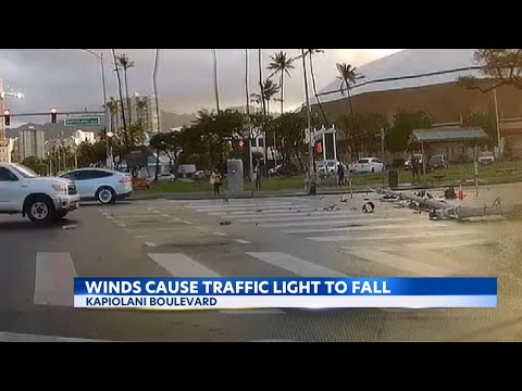 Strong winds bring down traffic pole, nearly missing cars