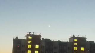 An unusually thin graceful moon in the evening sky, I'm trying to bring the moon closer in the video