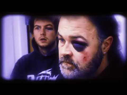 Deck hands wrestling a crab pot under floodlights in heavy spray