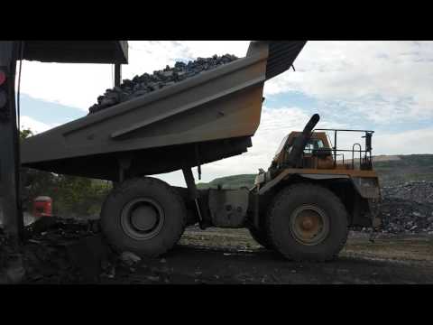 CAT 775B dumping limestone into the Grizzly