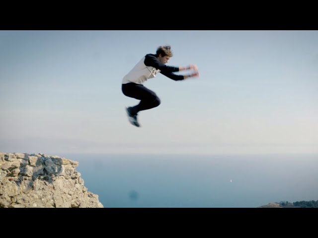Davide Garzetti a mezz'aria in un salto sopra una scogliera