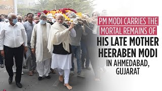 PM Modi carries the mortal remains of his late mother Heeraben Modi in Ahmedabad, Gujarat