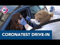 Zorgpersoneel rijdt door drive-in voor coronatest
