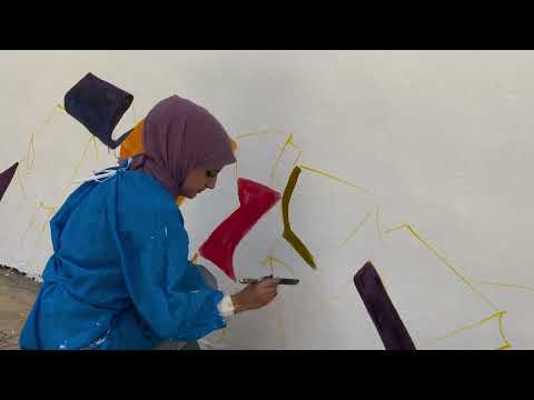 مشاركة الطالبة فاطمة رحيم حياوي من كلية القانون في الرسم على الجدار الخاص بمدخل الجامعة ايماناً منها