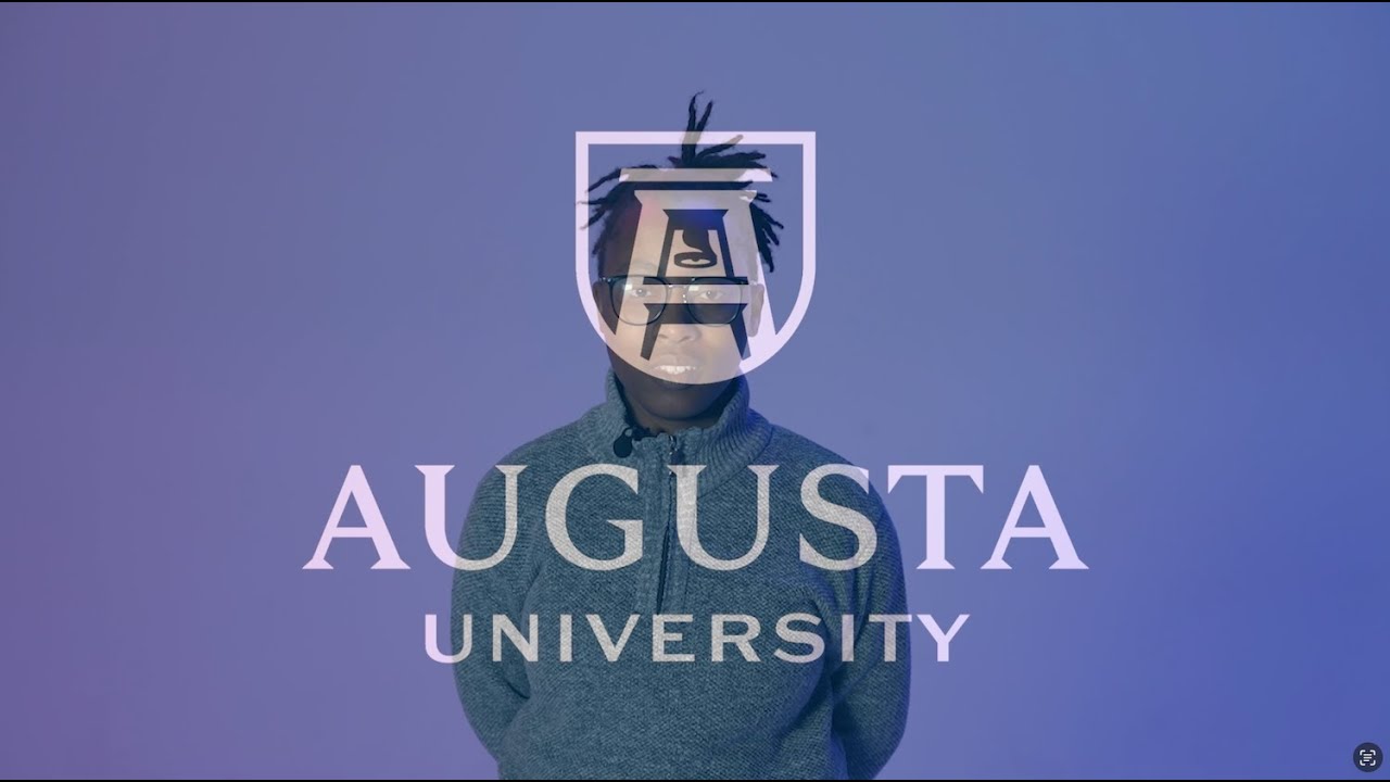 Student stands in front of a blue background&nbsp;