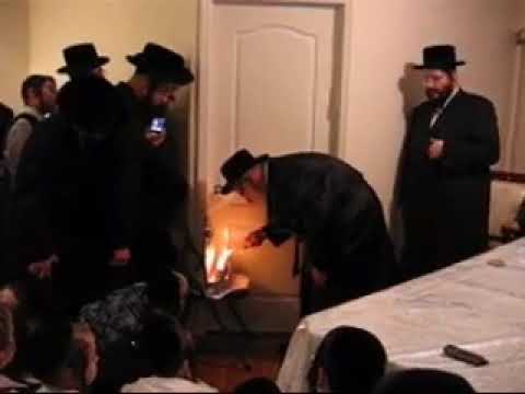 Reb Mendel Hager of Viznitz lighting Chanukah Menorah