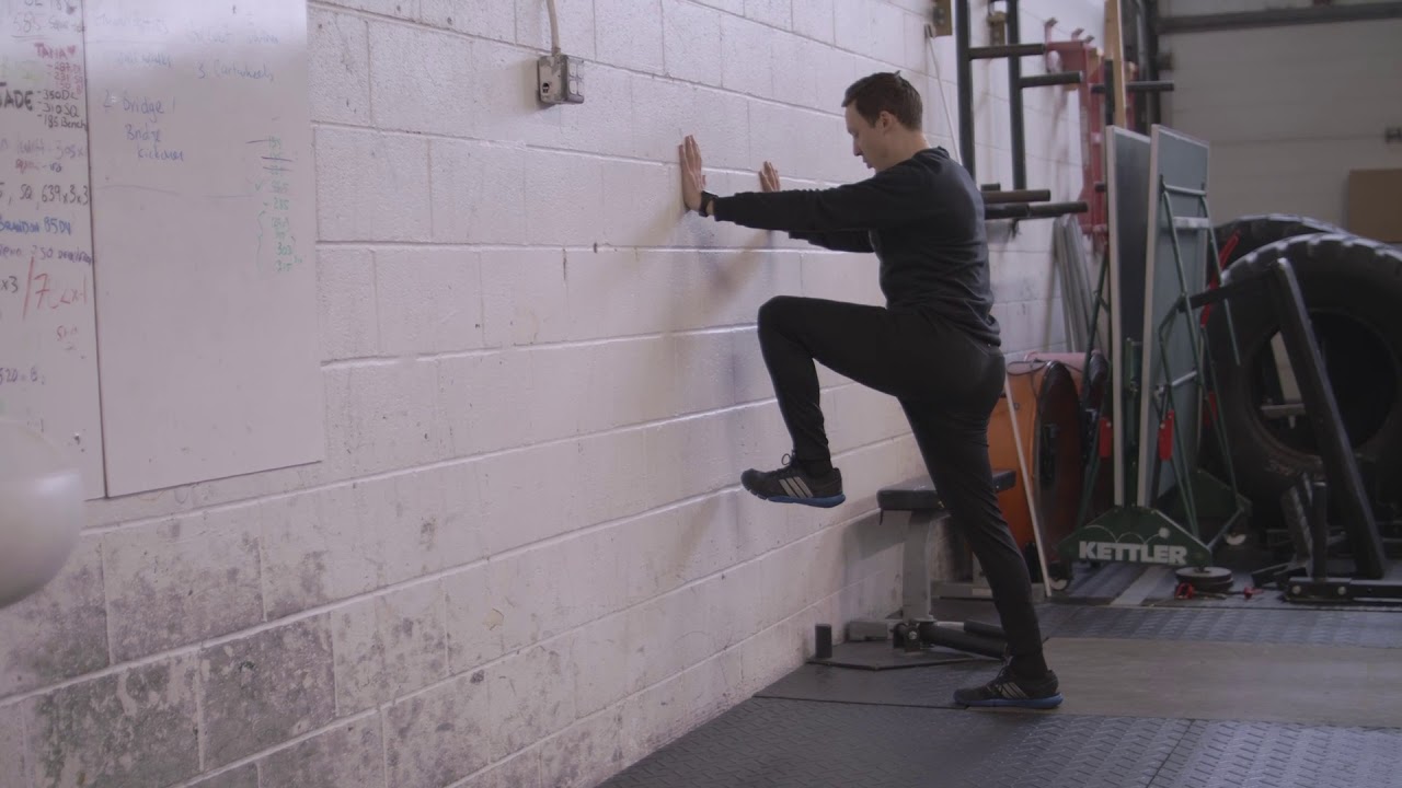 standing isometic wall march for glute activation - YouTube