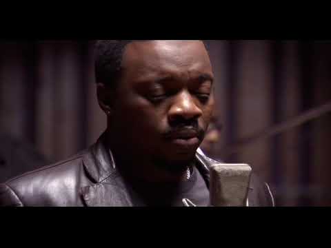 Trailer close-up: church pews and a handheld mic — the songs’ church roots in focus