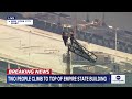 Two People Climb To The Top Of Empire State Building Spire Unfurl Banner