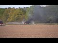 Brand slaat over van landbouwmachine op akker met riet