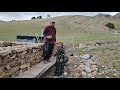 Building A Stone Structure In The Mountains Alongside The Slow Growth Of A Small Garden