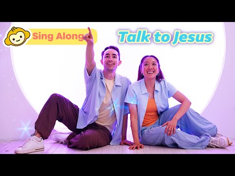 Two smiling hosts sit on the floor in pastel outfits, inviting viewers to sing along and talk to Jesus.