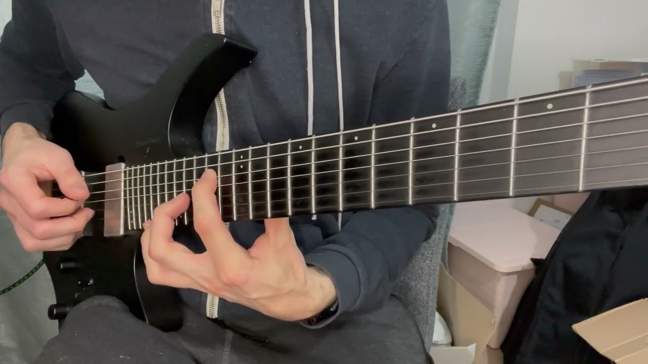 Guitarist demonstrating a hybrid picking octave lick, striking the low string with a pick and plucking the high octave with a finger.